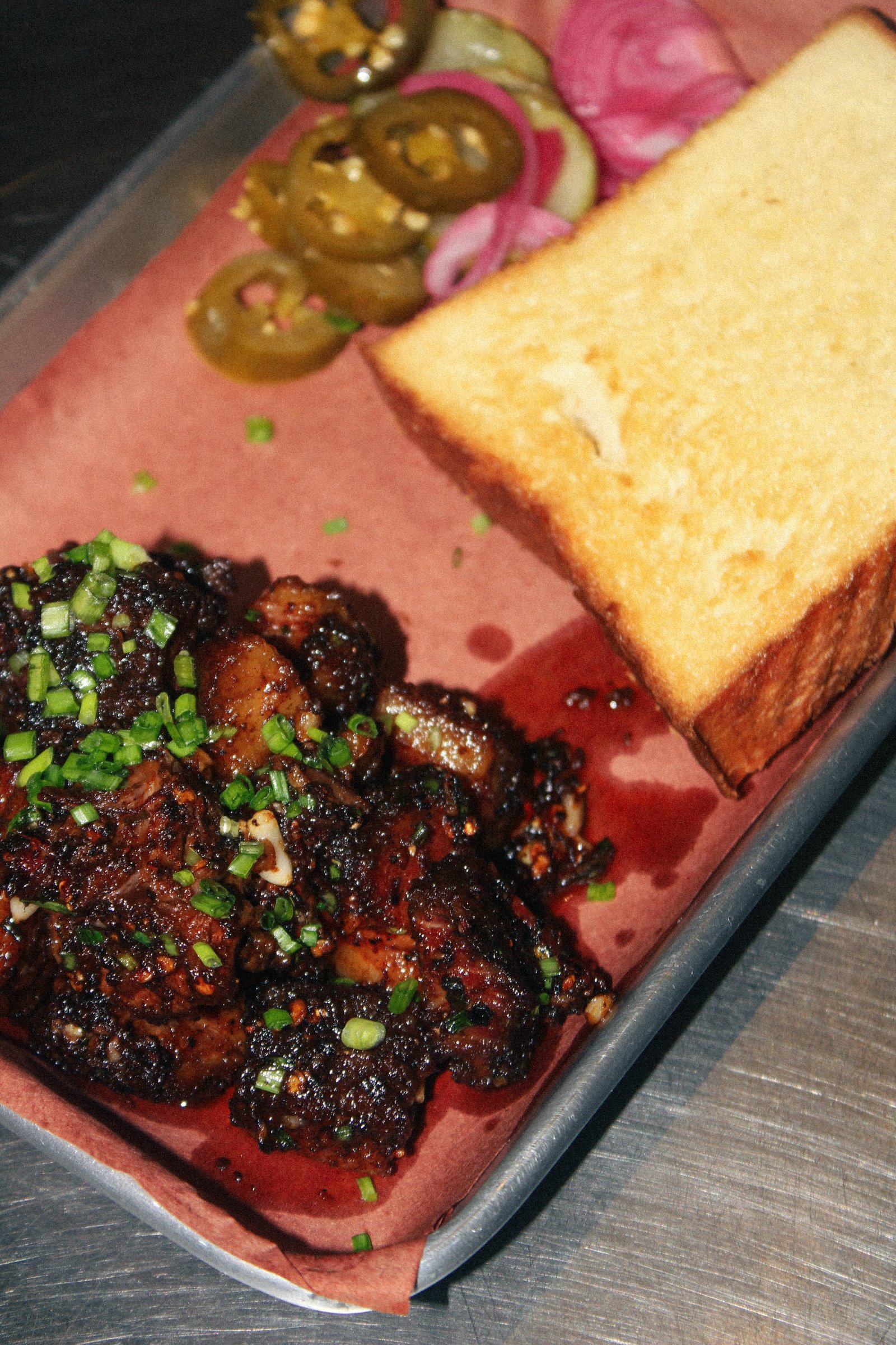 Glazed smoked meat with toast on a metal tray