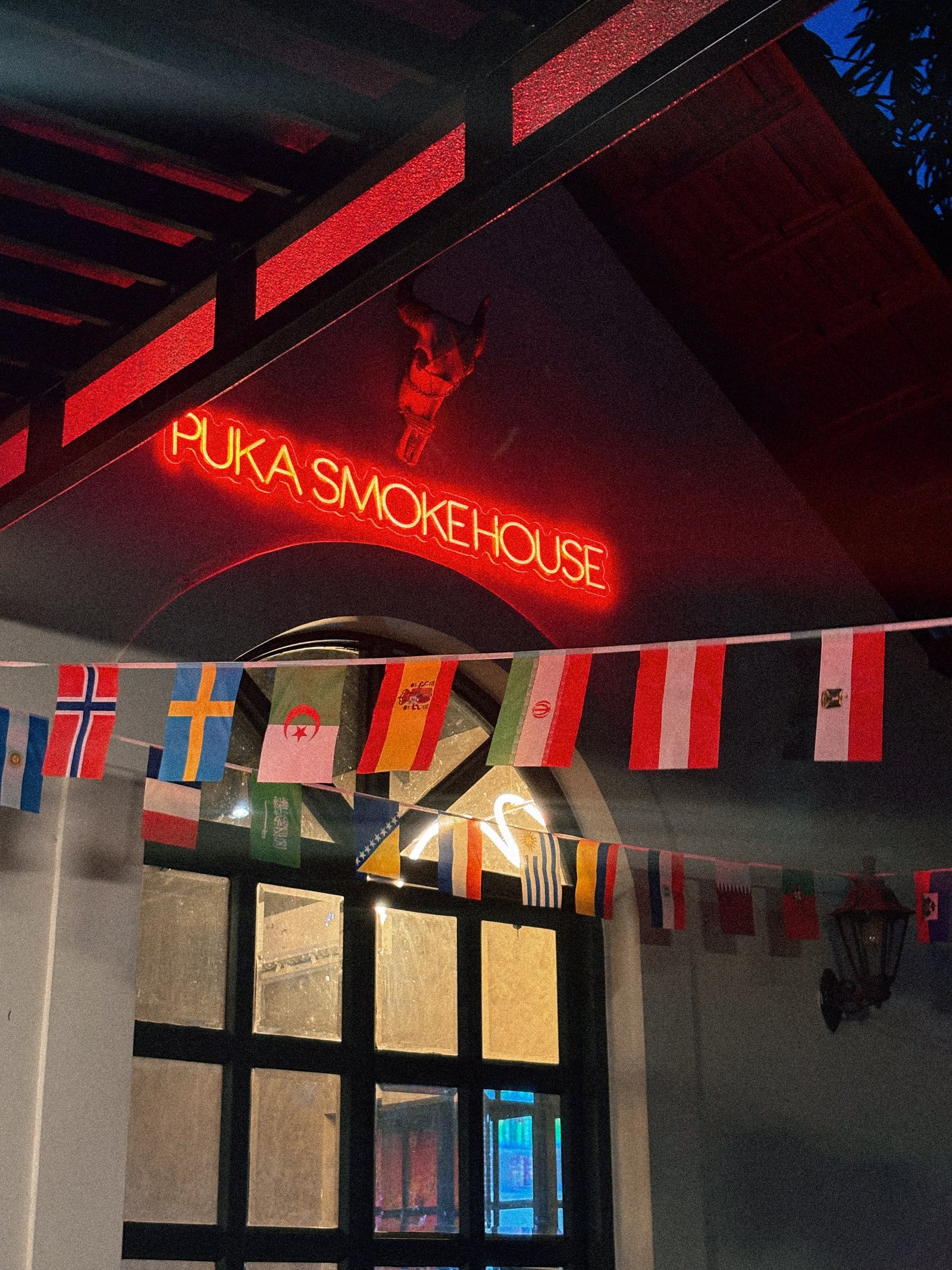 PuKa Smokehouse neon sign glowing at night